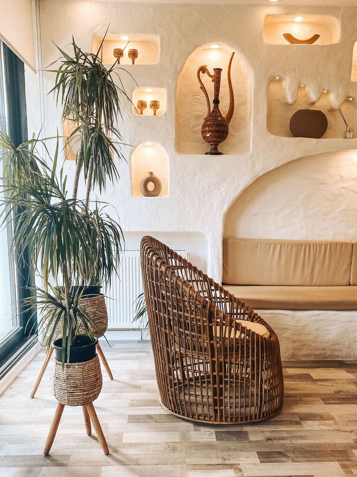 Plaster niches and a rattan chair in a warm, light-filled room