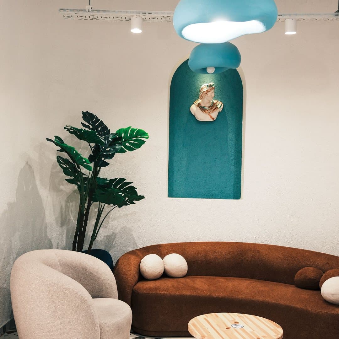 Reception lounge with a curved sofa below a teal arched niche